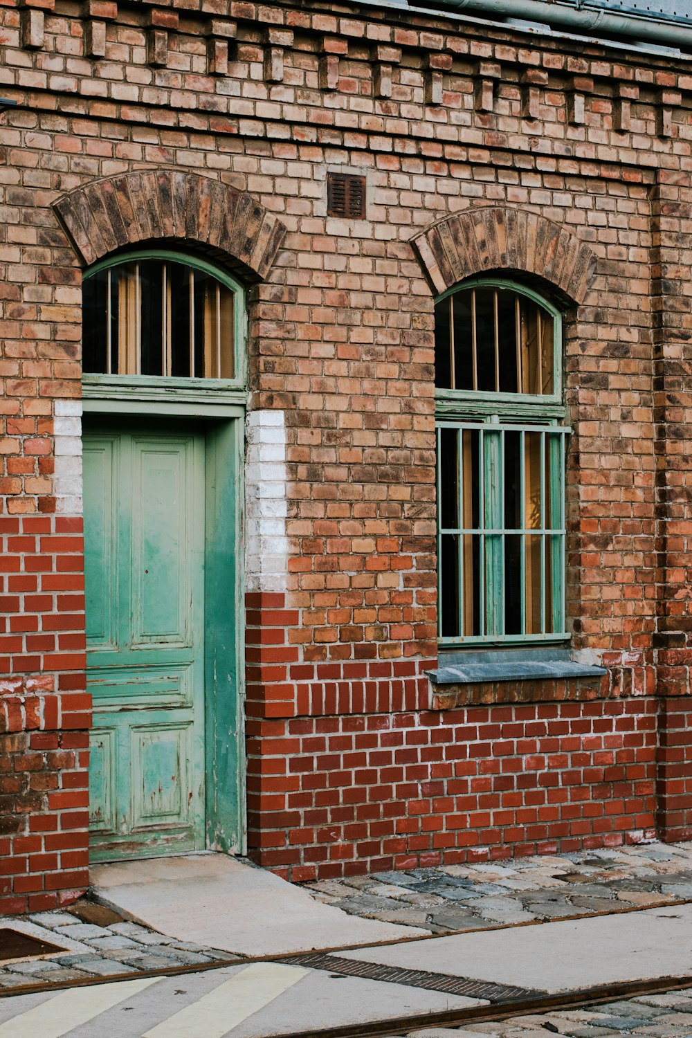 a brick building with a green door and window