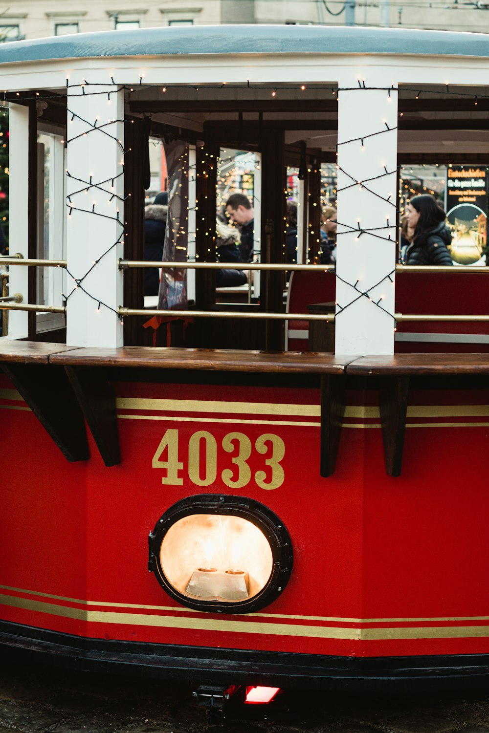a red and gold trolley car with people on it