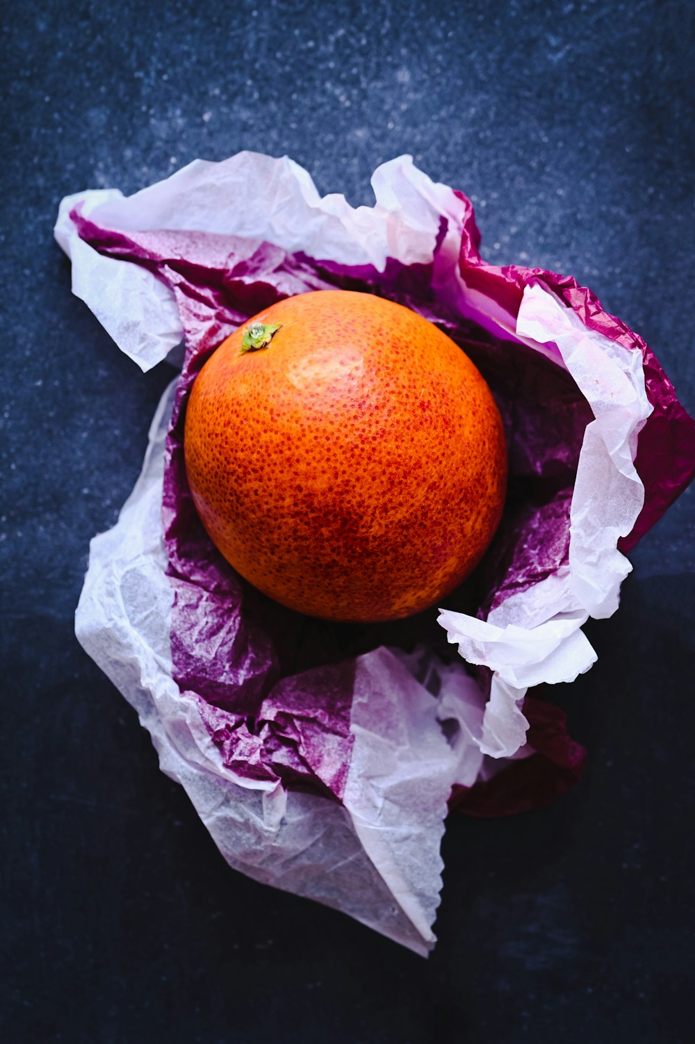 an orange sitting on top of a piece of paper