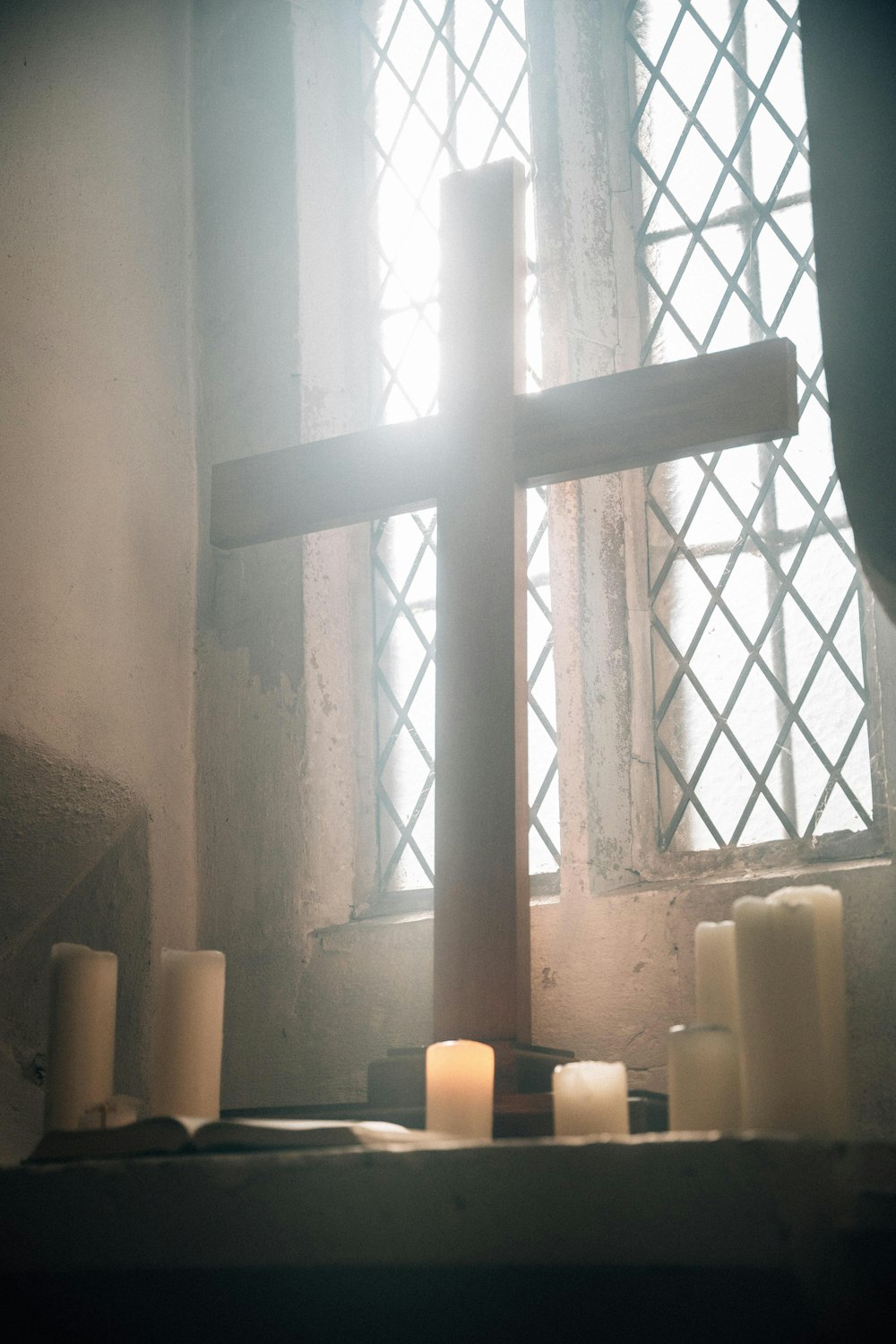 a cross and candles in front of a window