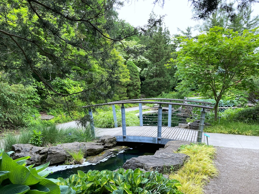 a wooden bridge over a small stream in a park