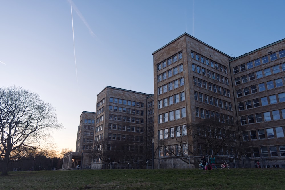 a group of buildings sitting on top of a lush green field