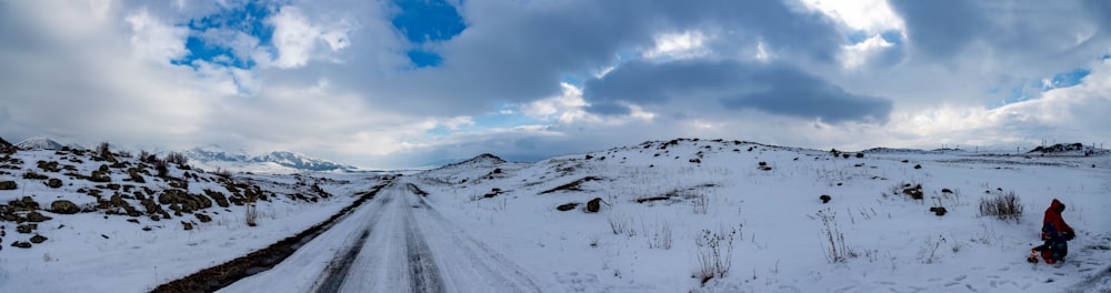 a snow covered road with a mountain in the background