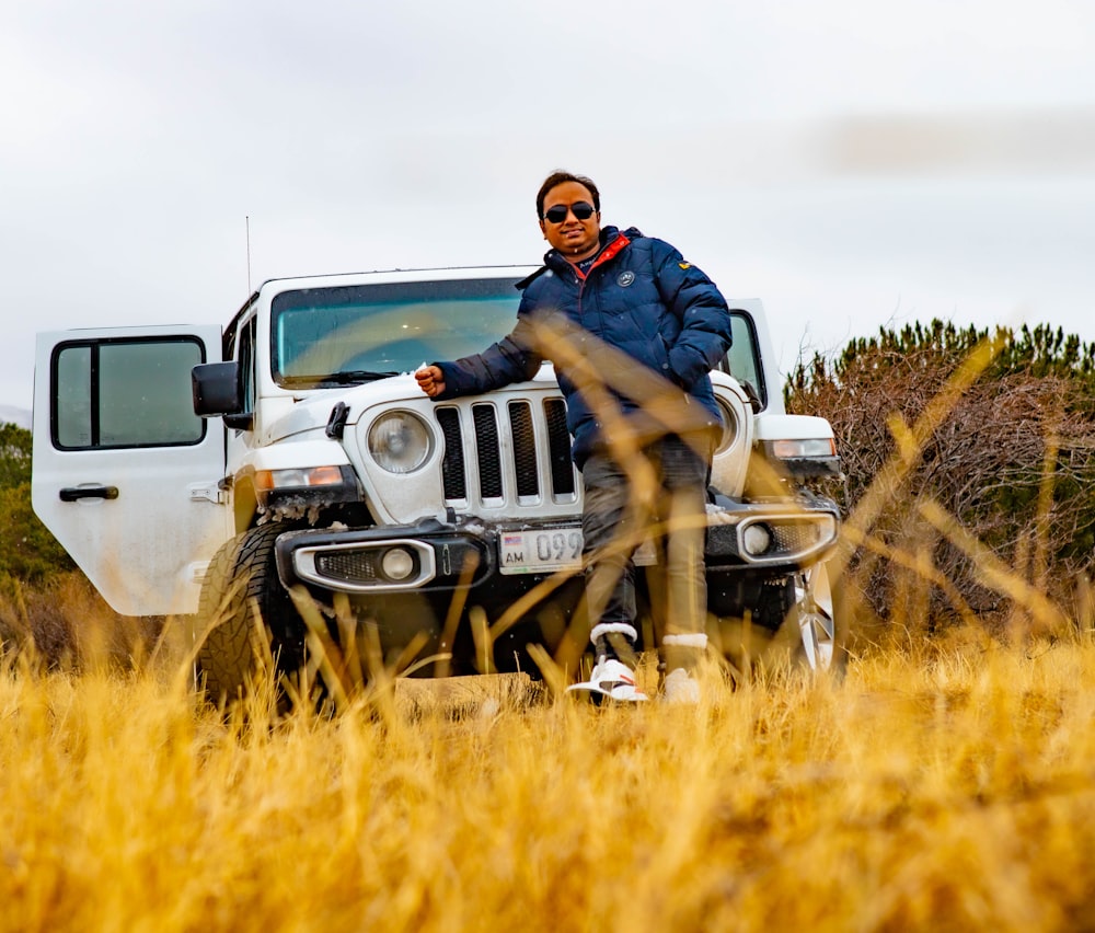 a man sitting on top of a white jeep
