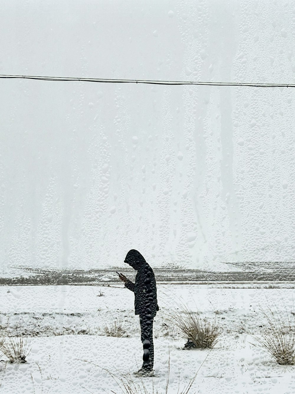 a person standing in the snow with a cell phone