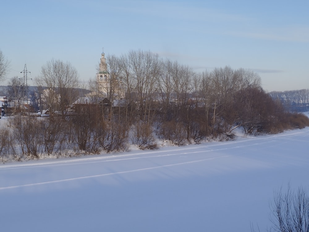 eine verschneite Landschaft mit einer Kirche in der Ferne