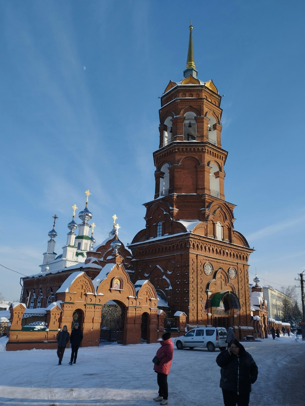 two people standing in front of a church in the snow