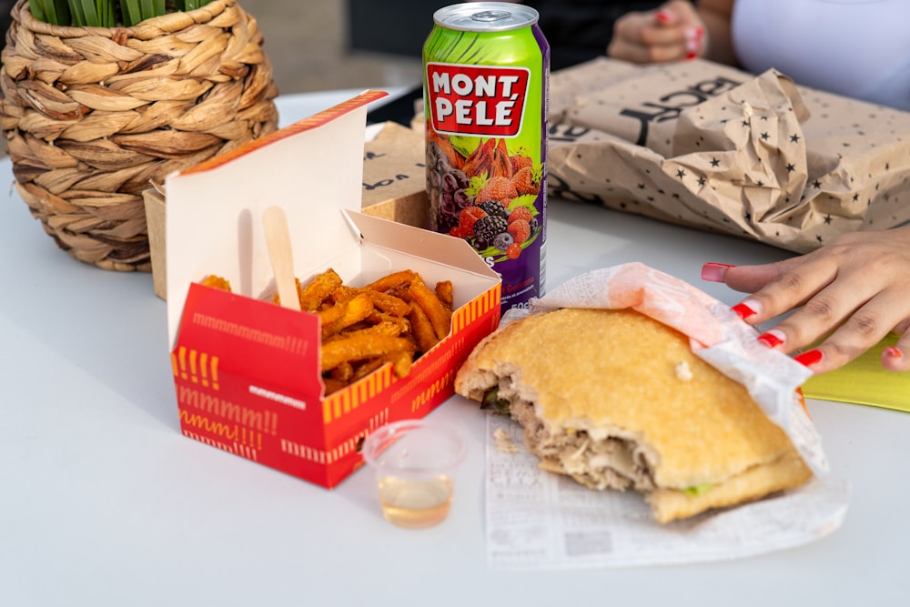 a table with a half eaten sandwich and a can of donut pelle