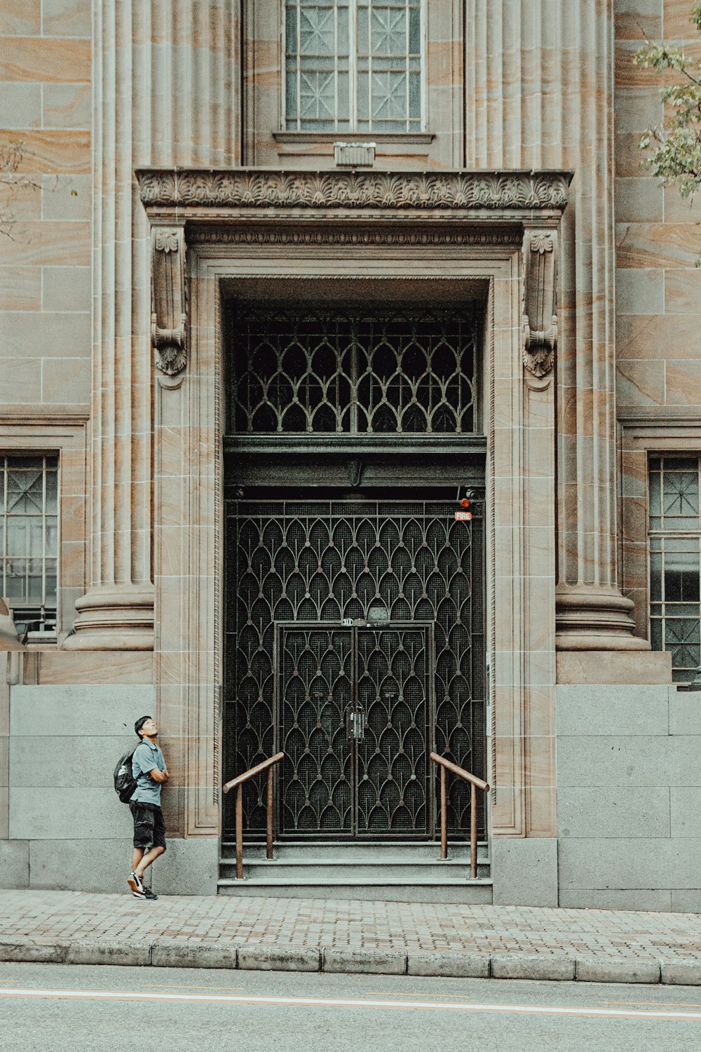 a woman walking down a street past a tall building