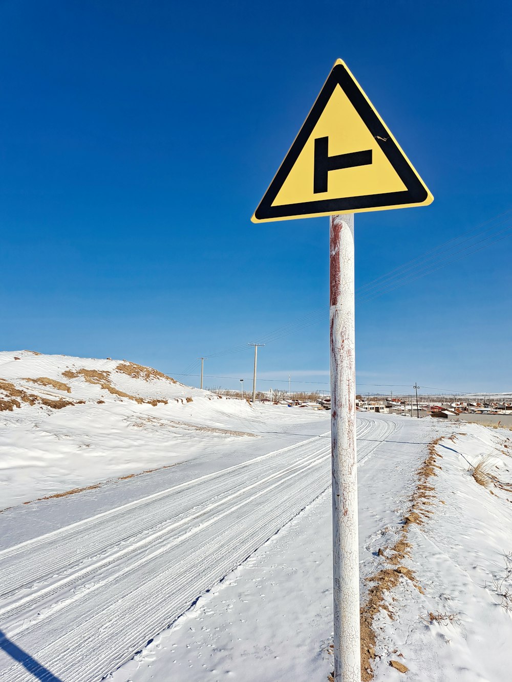 a yellow and black sign sitting on the side of a road