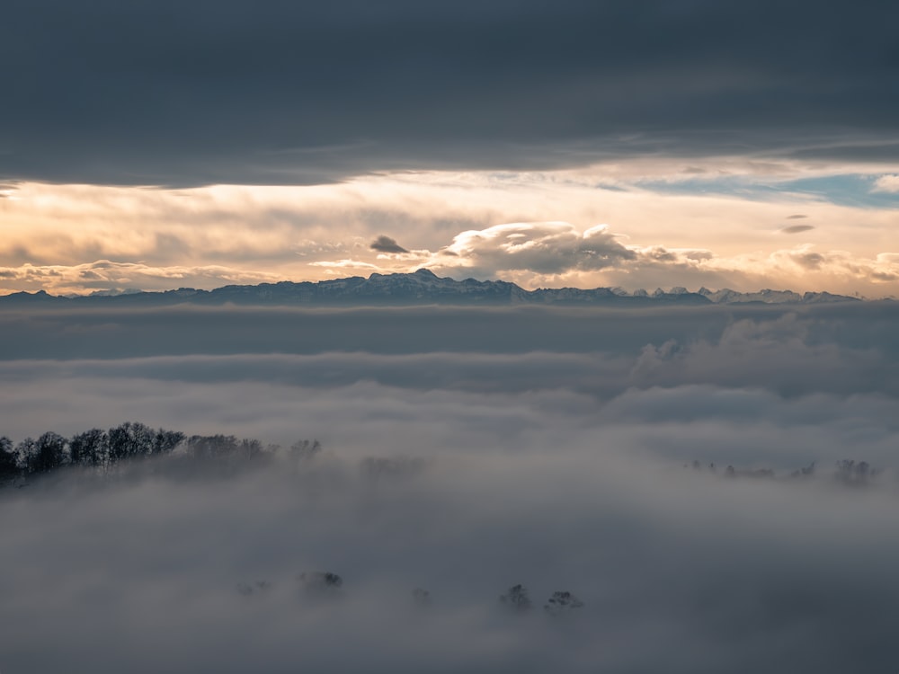 a view of a mountain covered in low lying clouds