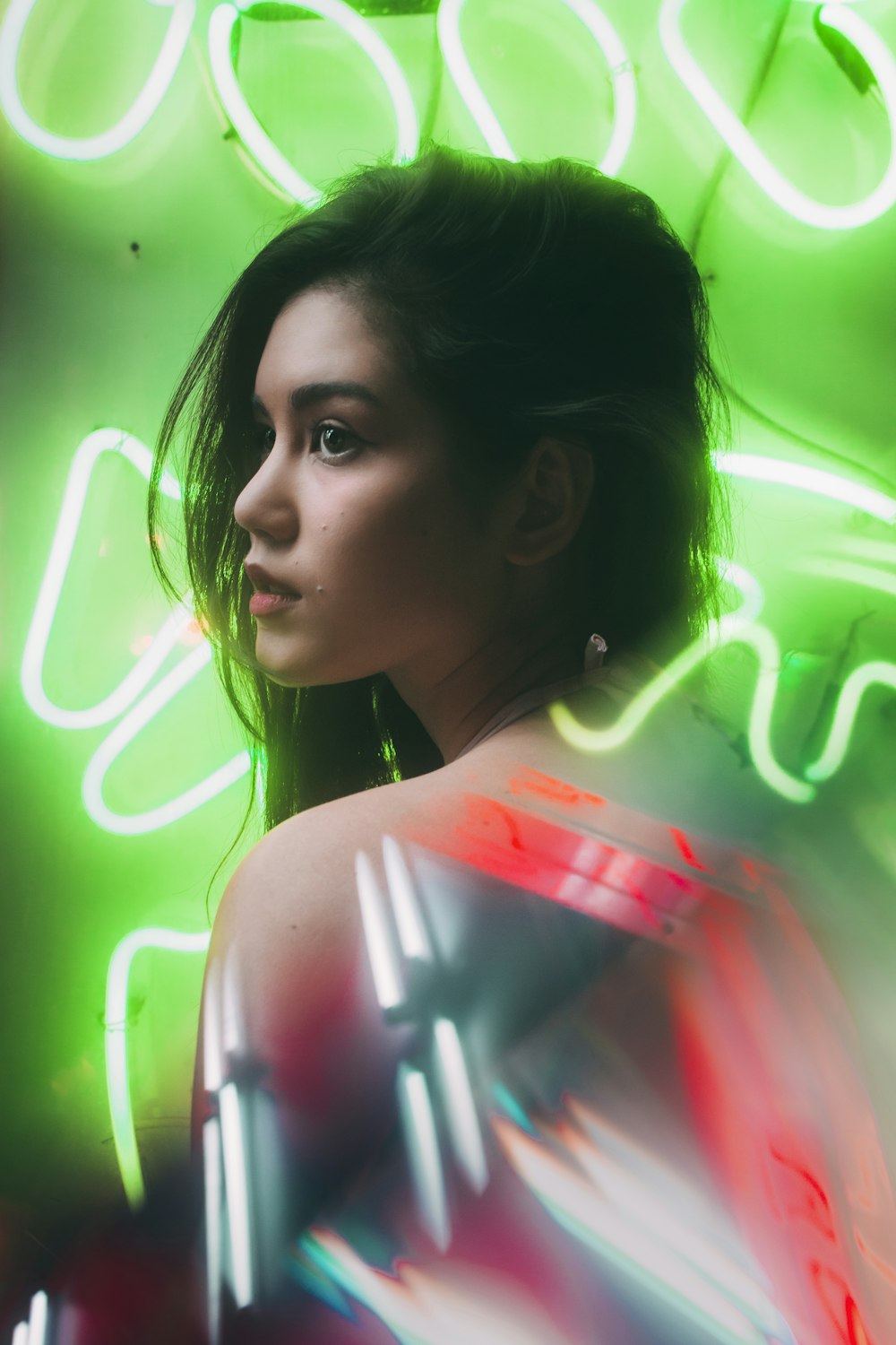 a woman standing in front of a neon sign