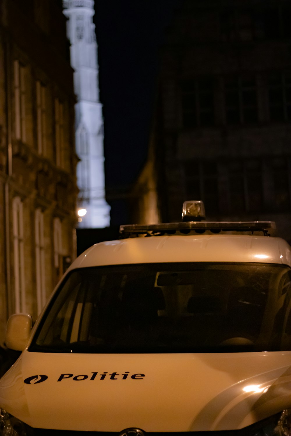 a white police car parked in front of a tall building