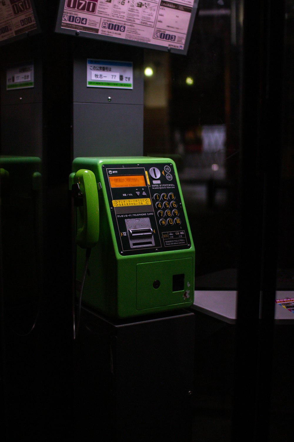 une machine verte à côté d’un parcomètre