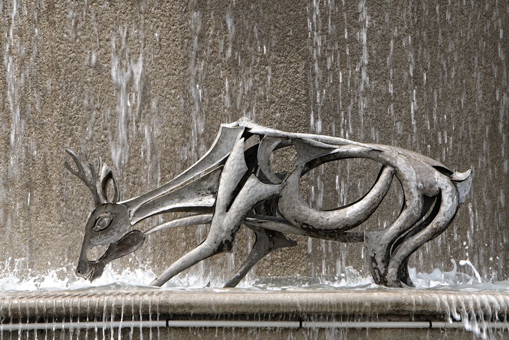 a statue of a deer in front of a fountain