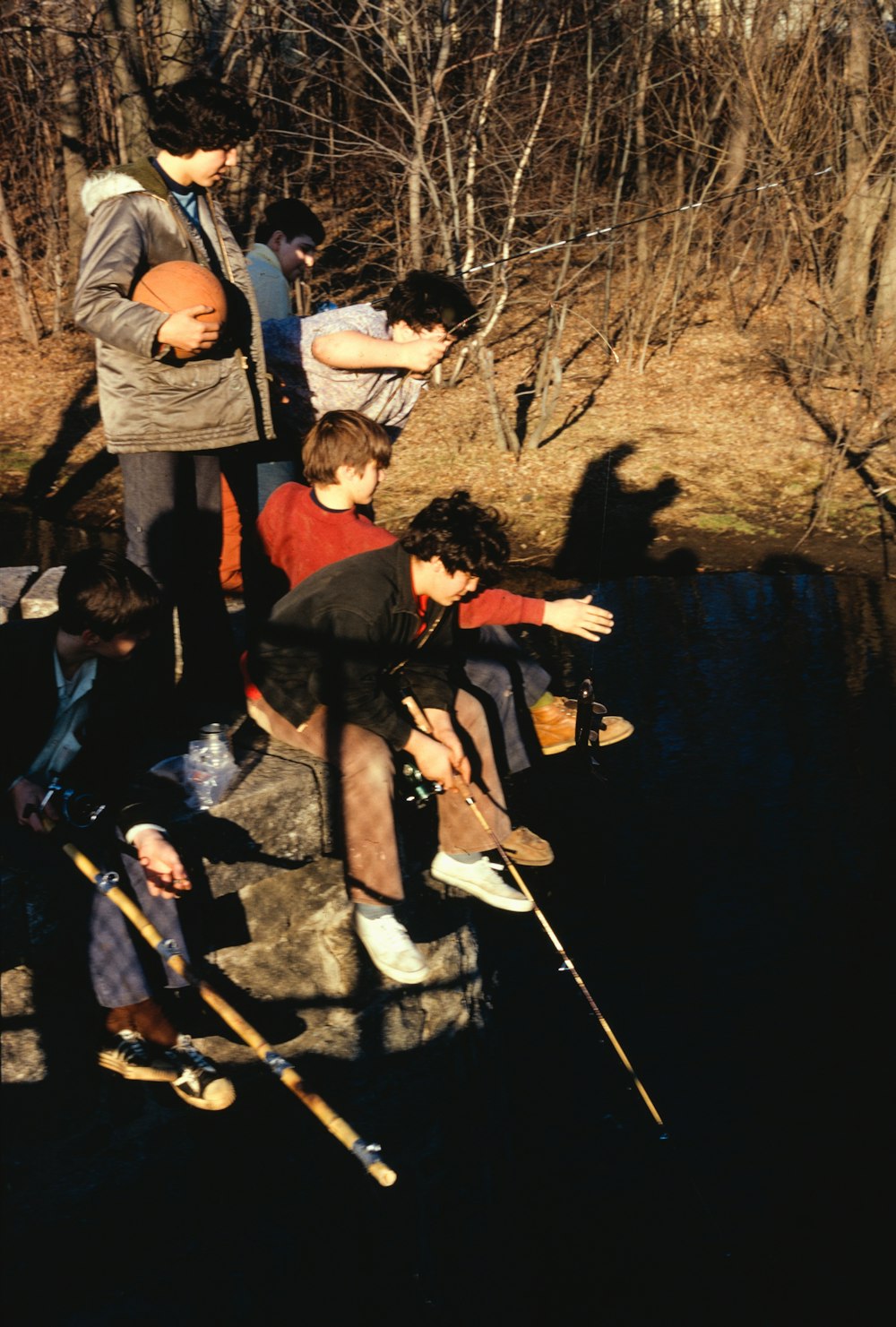 a group of people standing around a body of water