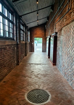 a brick walkway with a manhole in the middle of it