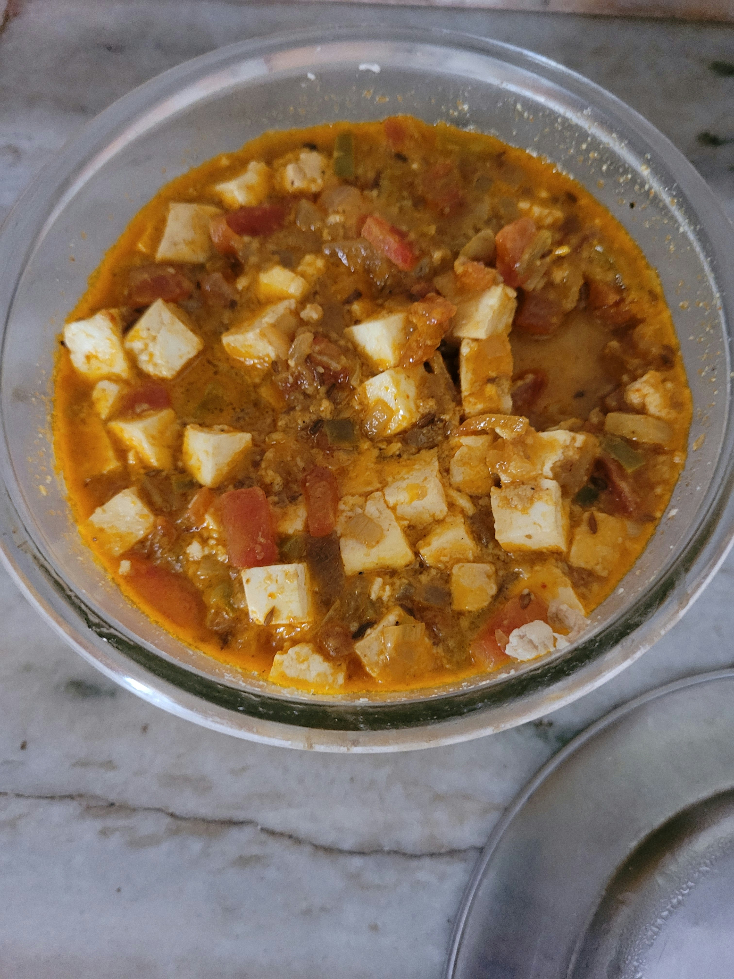 Rich paneer matar masala with white paneer cubes and green peas in a vibrant red-orange tomato gravy