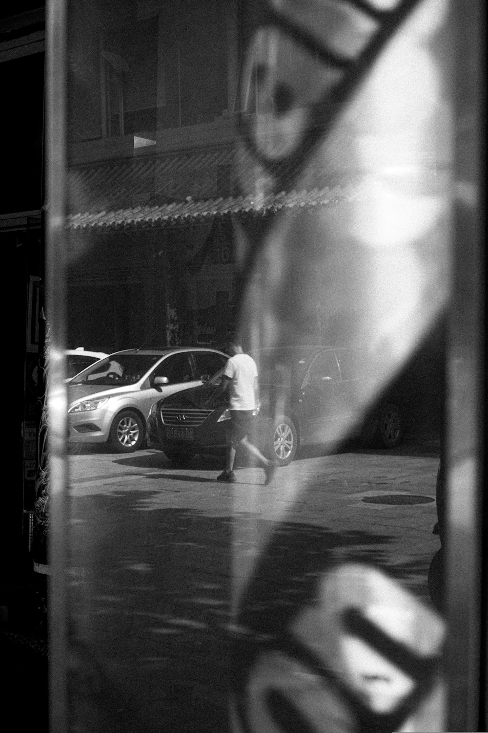 a man walking down a street next to parked cars