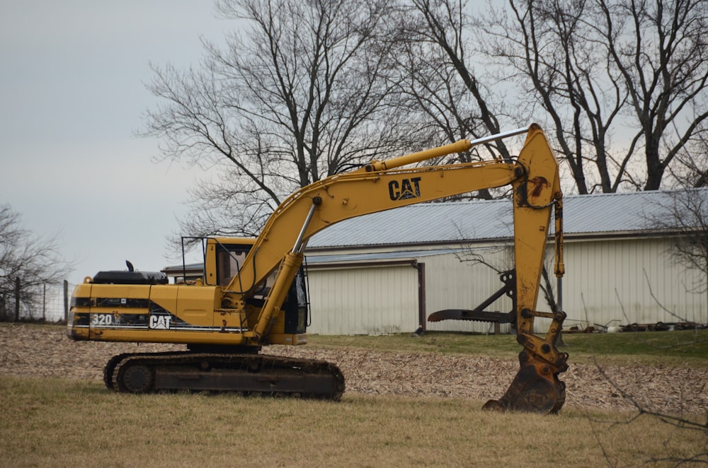 a large yellow excavator sitting in a field