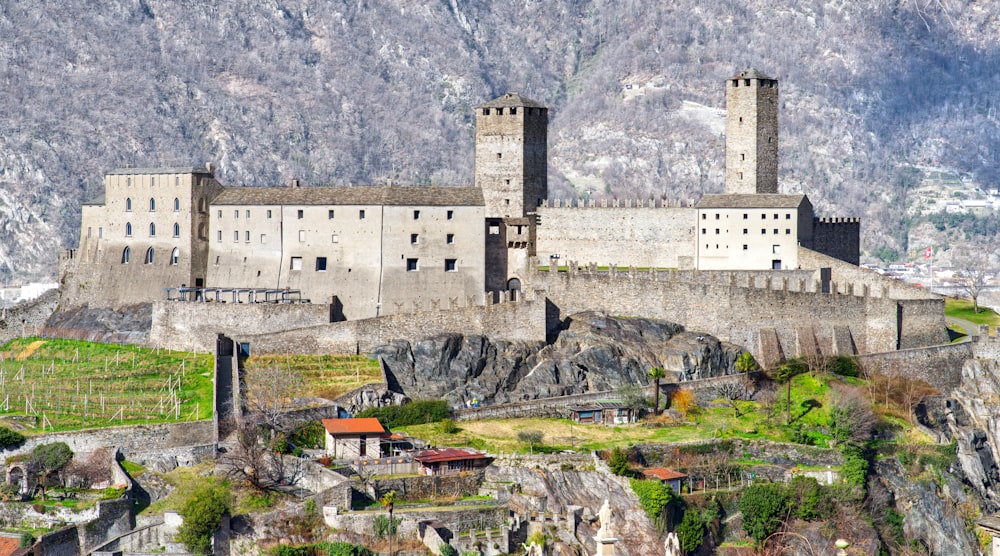 a castle on top of a mountain surrounded by mountains