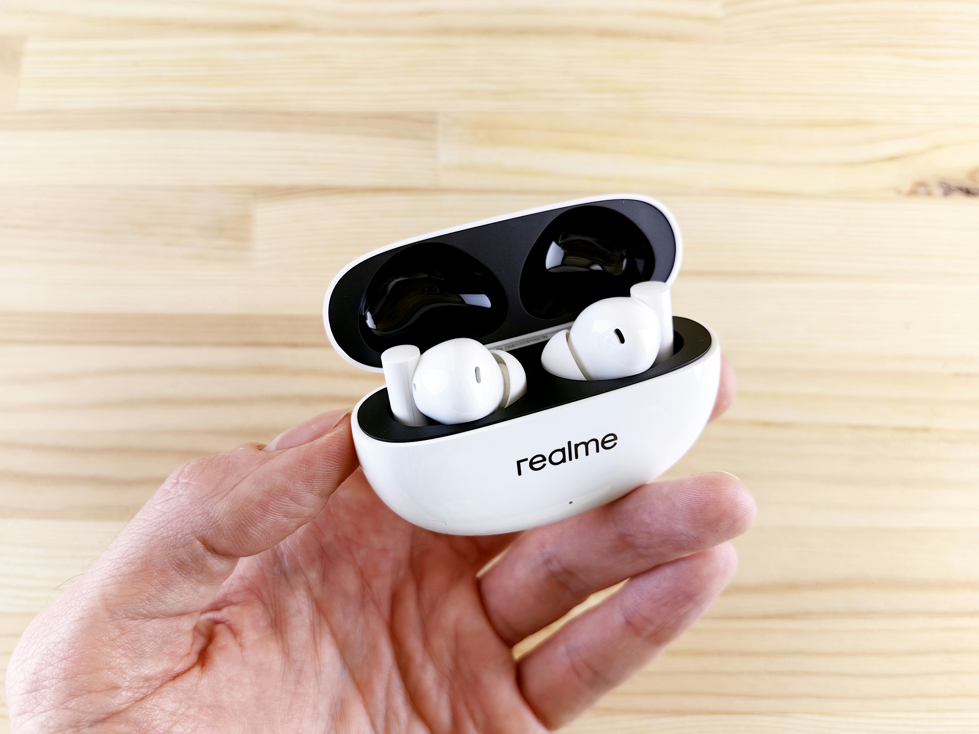 a person holding a pair of earbuds in their hand
