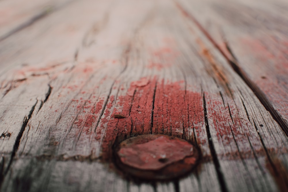 um close up de um pedaço de madeira com tinta vermelha