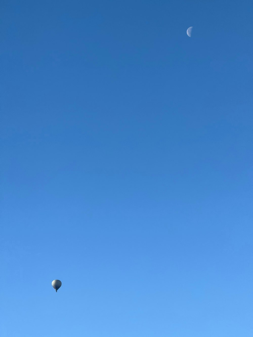 a group of people flying kites in a blue sky