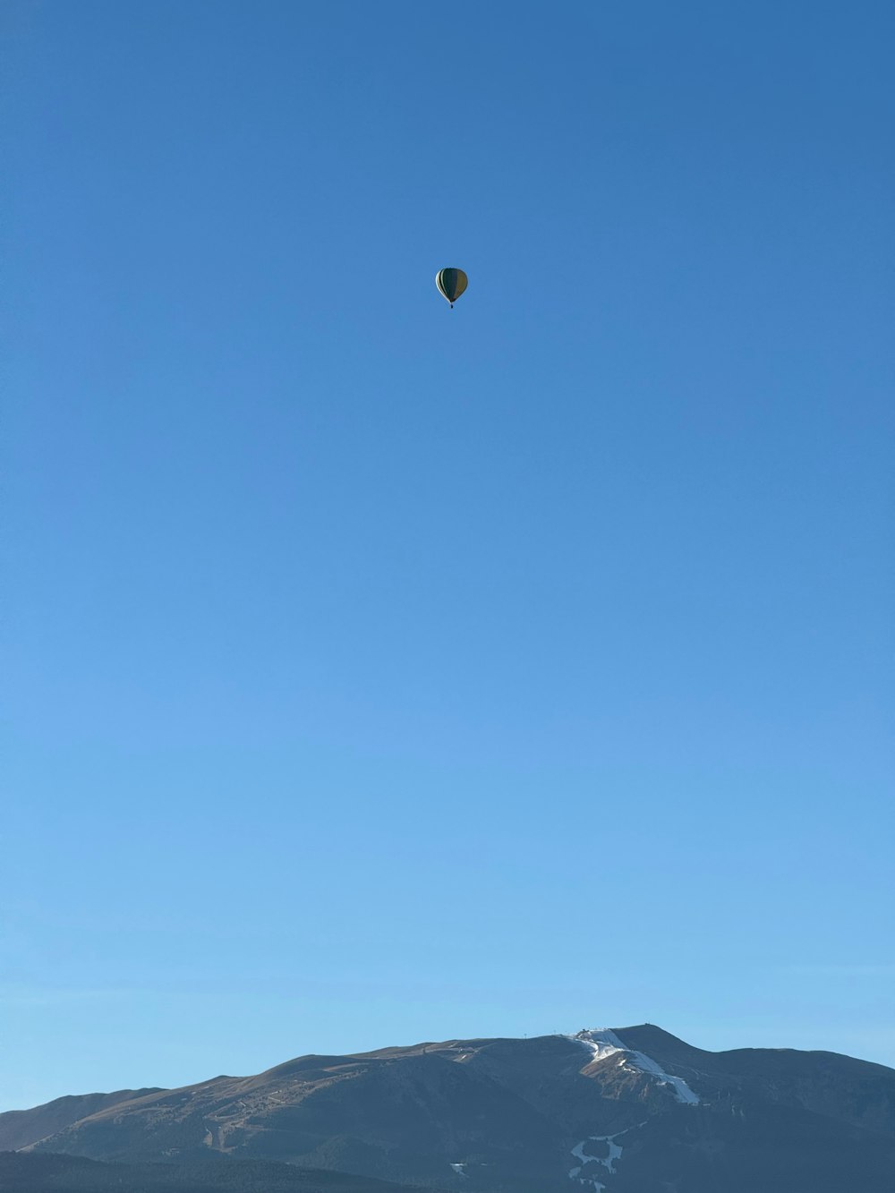 um balão de ar quente voando sobre uma cordilheira