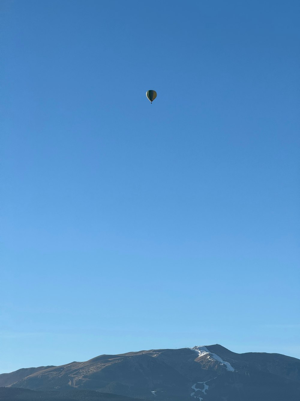 a hot air balloon flying over a mountain range