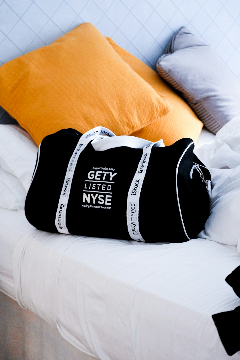 a black duffle bag sitting on top of a bed