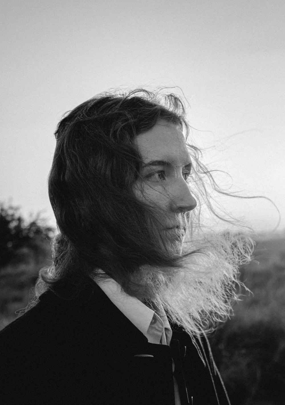 a black and white photo of a man with long hair