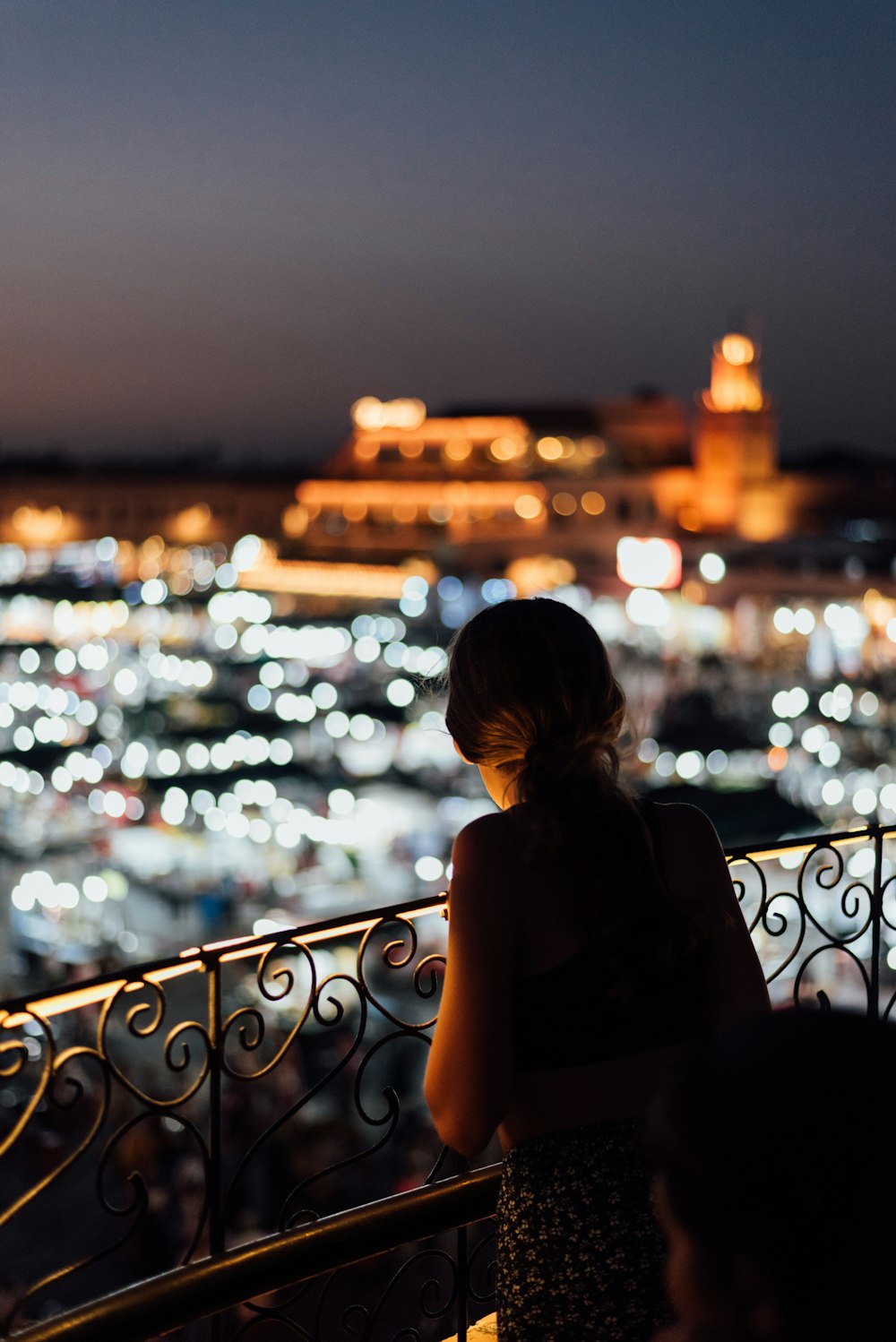 a woman looking out over a city at night