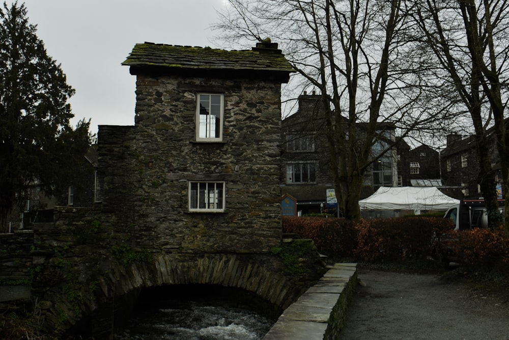 a stone building with a small bridge over a stream