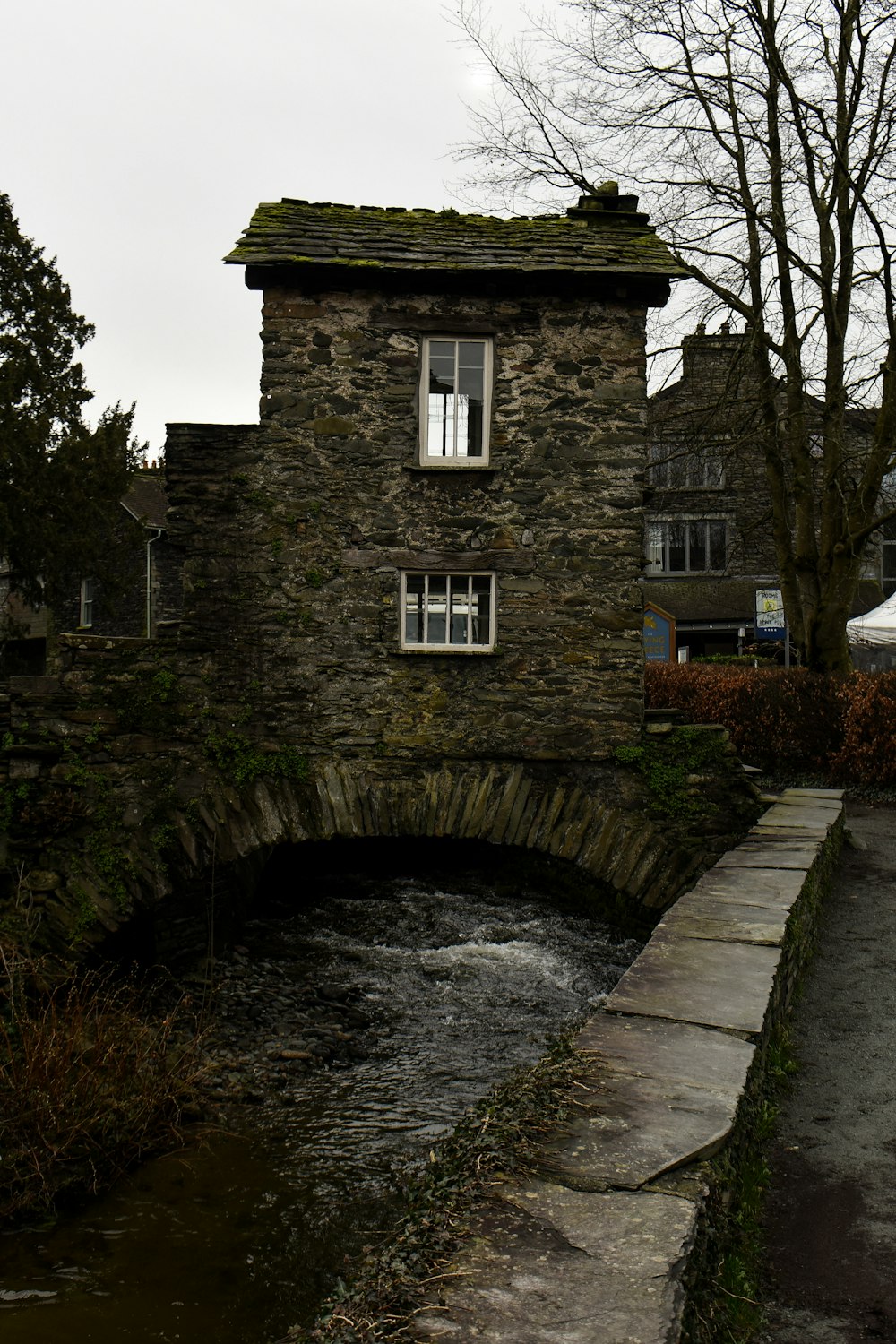 a stone building sitting next to a river