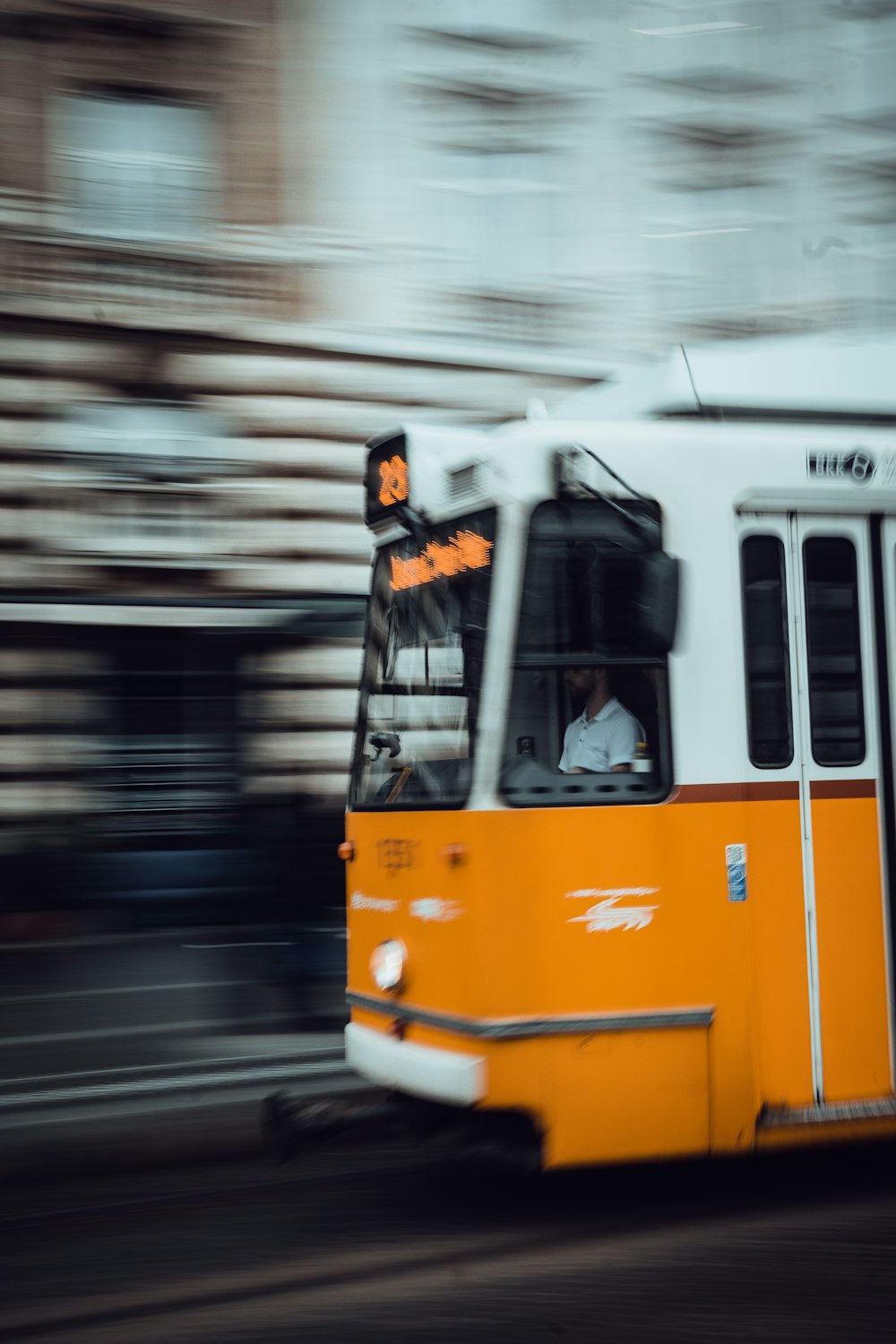 a yellow and white bus driving down a street