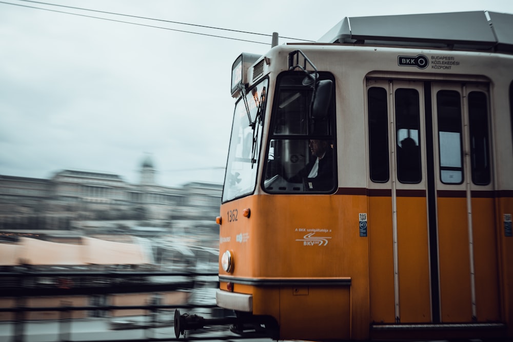 an orange and white train traveling down train tracks