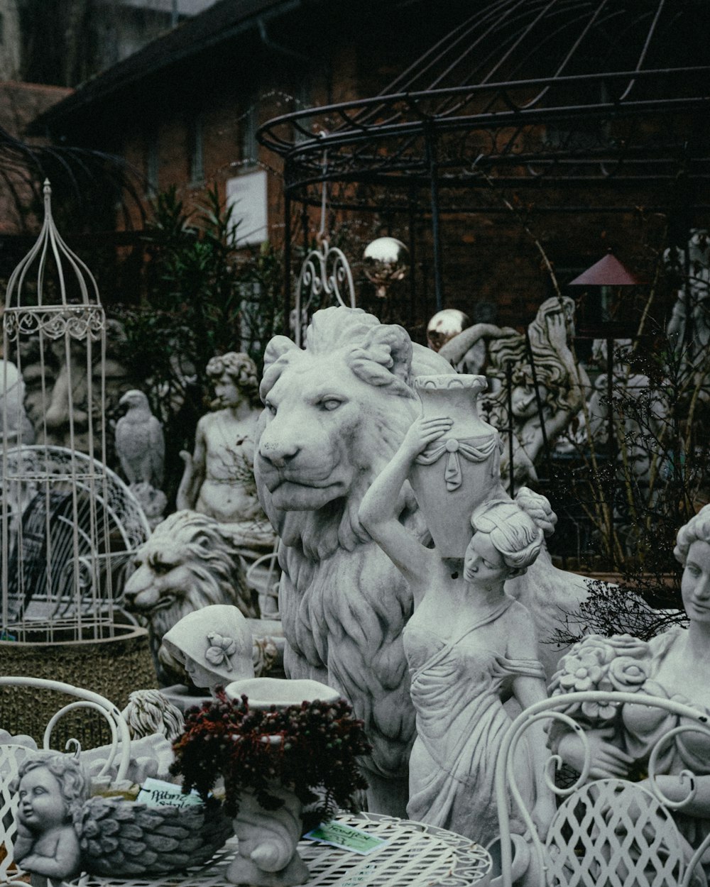 a white statue of a lion surrounded by other statues
