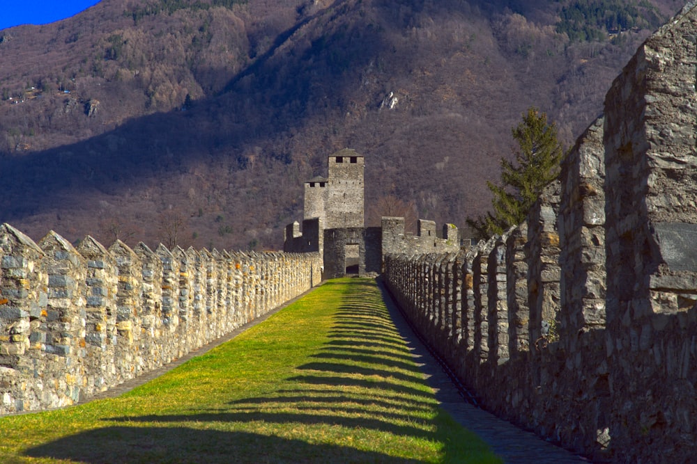 a stone wall and a stone fence with a mountain in the background
