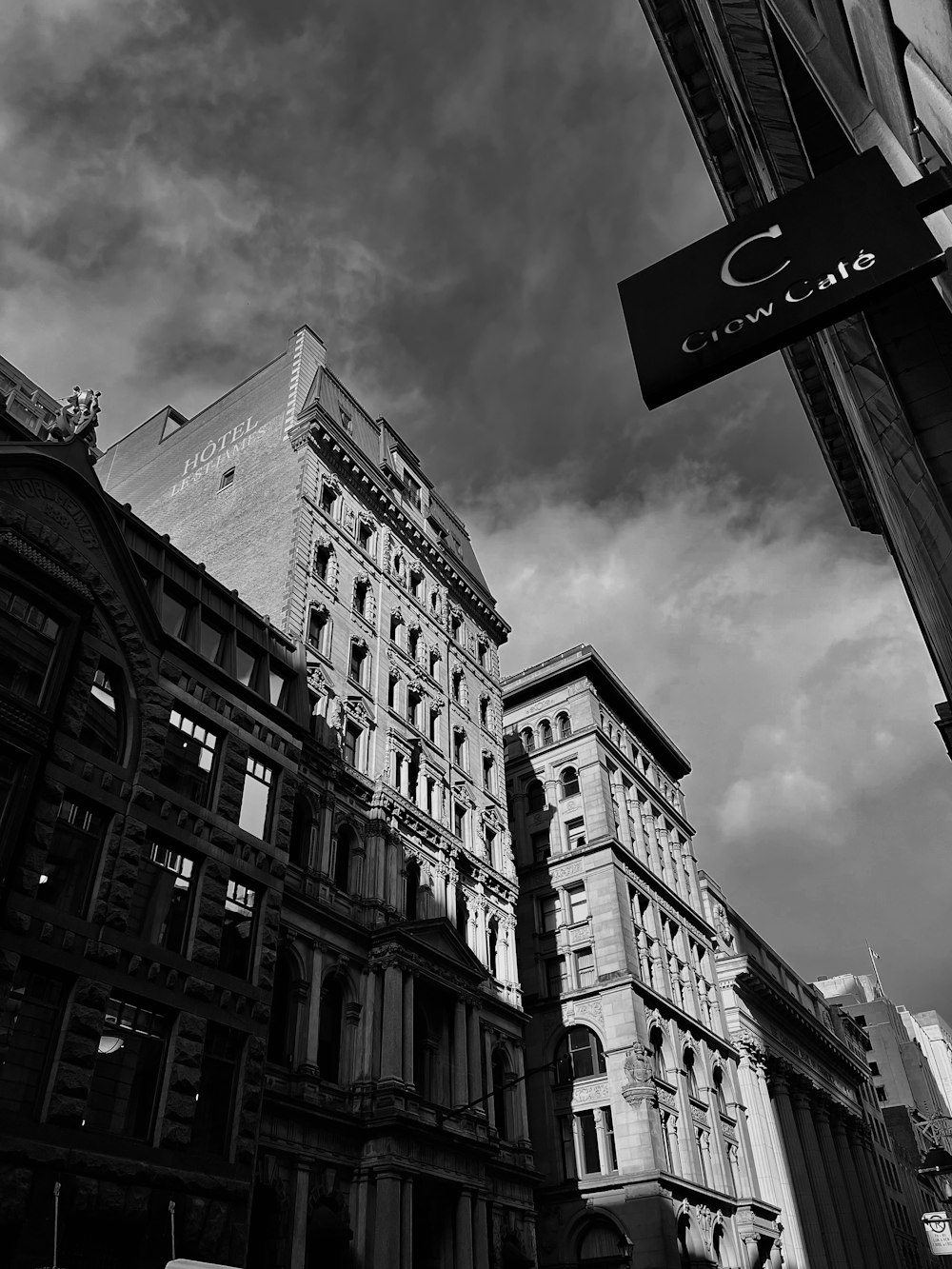 a black and white photo of a building and a street sign