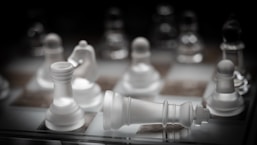 a close up of a chess board with white pieces
