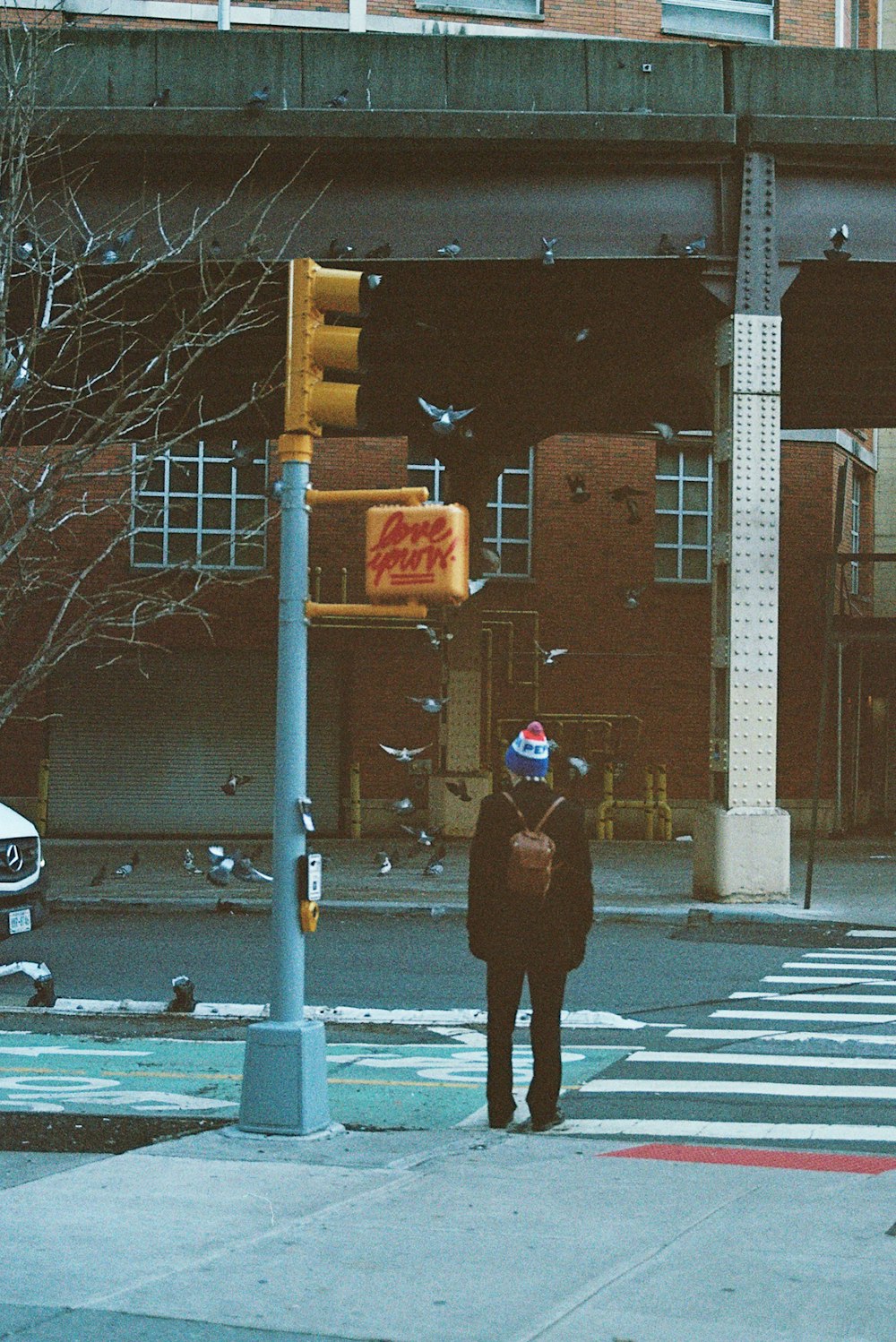 a man standing on the side of a road next to a traffic light