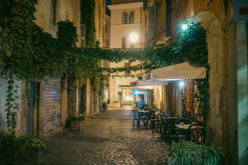 a cobblestone street with tables and chairs at night