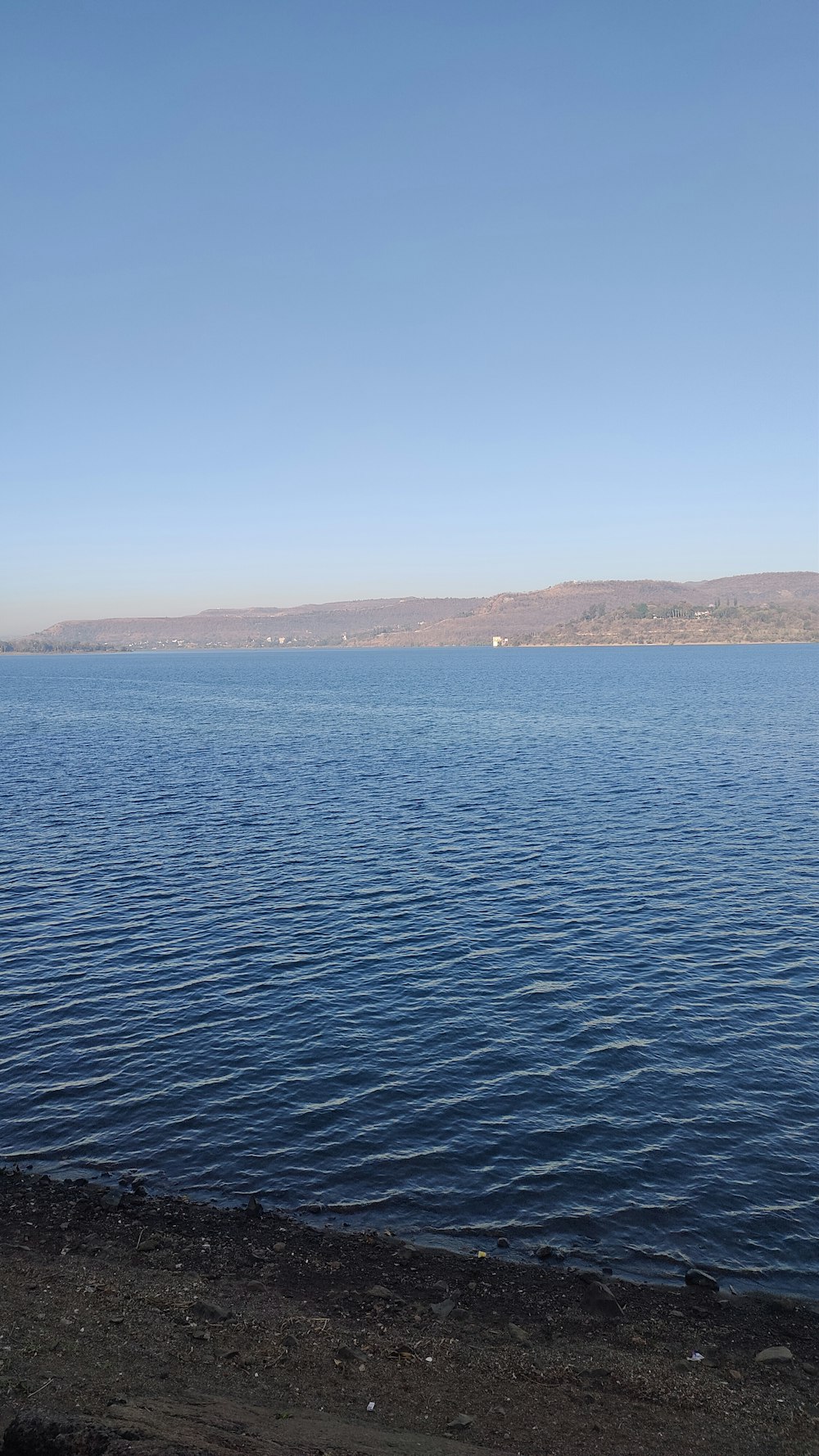 a large body of water sitting under a blue sky