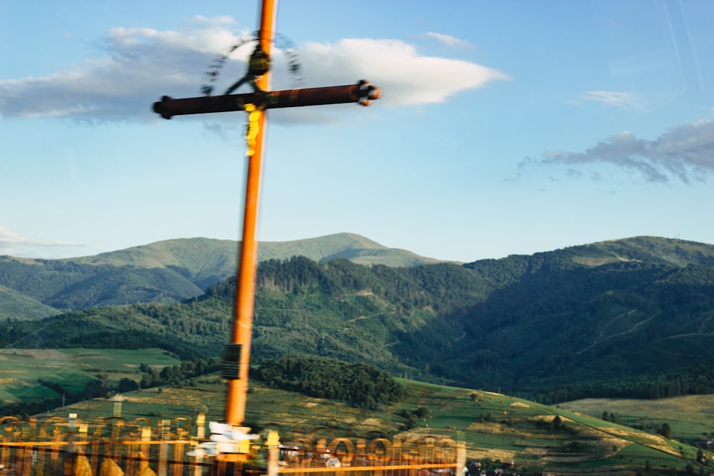 a cross on top of a pole in the middle of a field