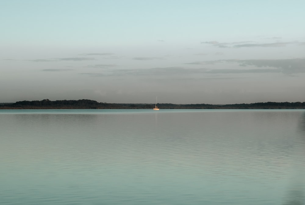 a large body of water with a boat in the distance