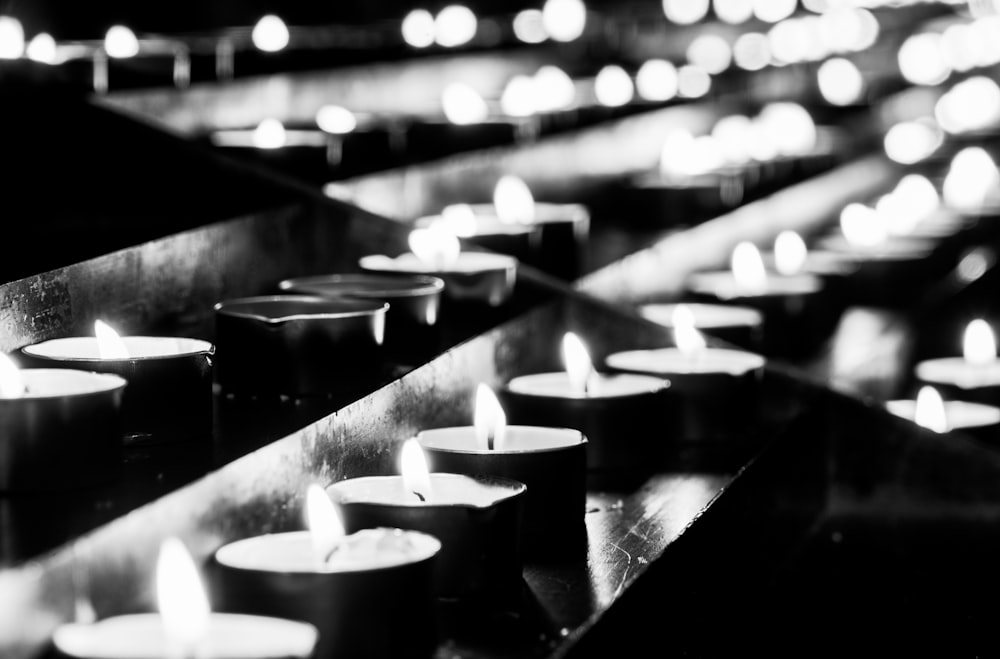 a row of lit candles sitting on top of a table