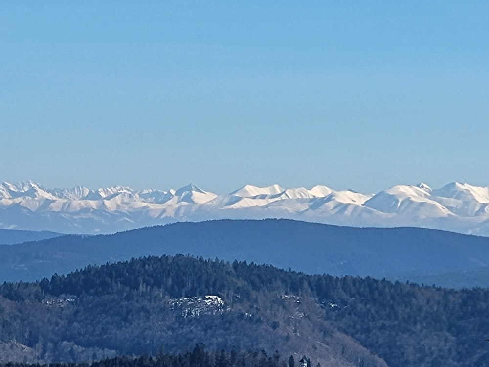 a view of a mountain range with snow capped mountains in the distance
