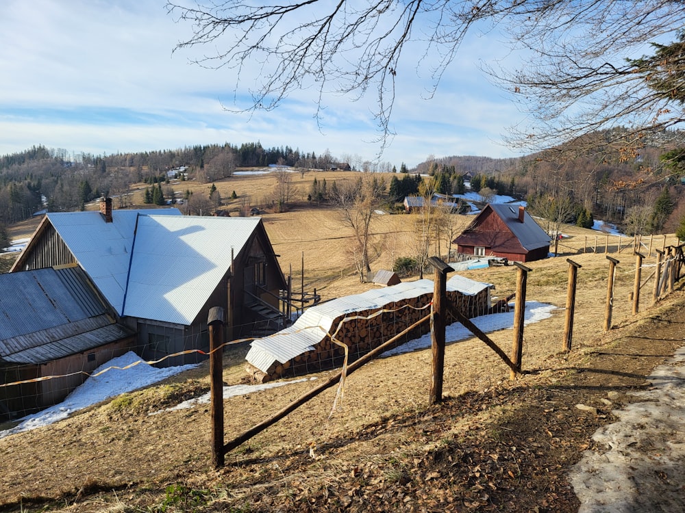 a farm with a fence and a barn in the background