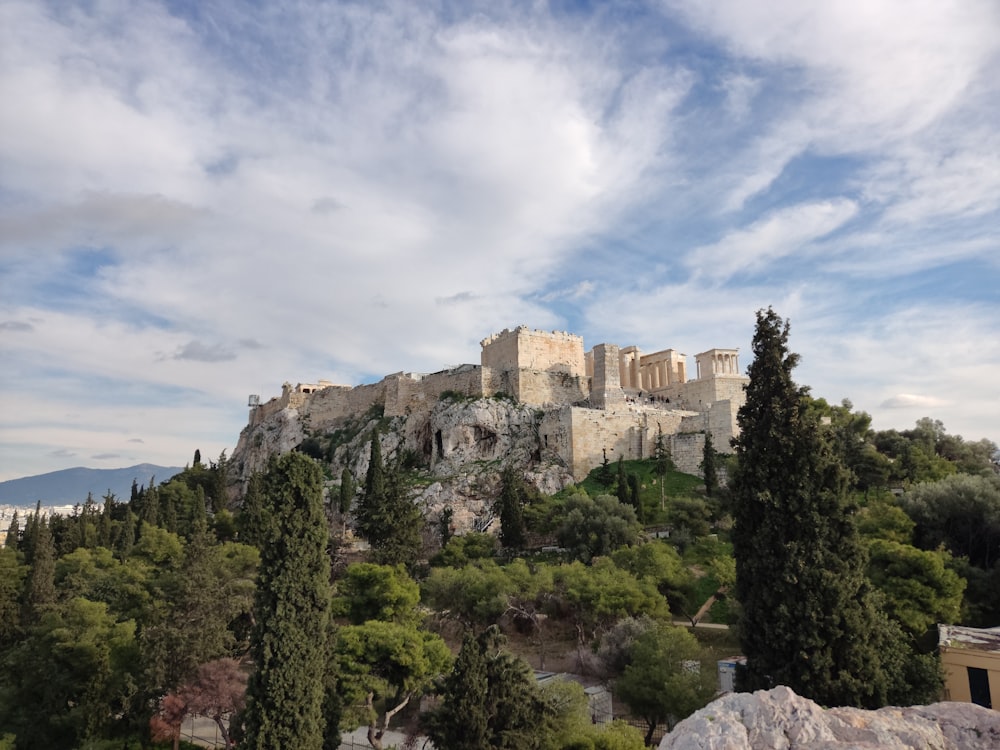 a castle on top of a hill surrounded by trees